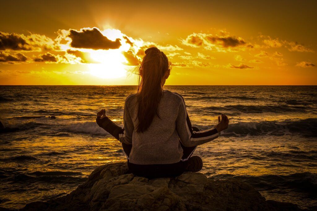 girl meditating on a beach